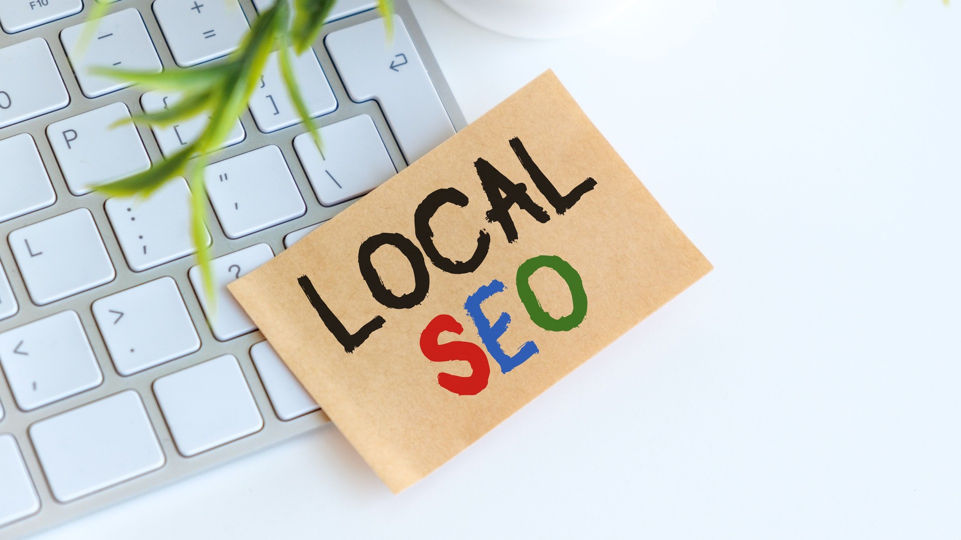 A keyboard with a piece of paper that says Local SEO on it